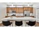 Modern kitchen featuring stainless steel appliances, quartz countertops, and island with barstool seating at 6240 N Dayton Ct, Denver, CO 80238