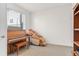 Bright bonus room with a piano, massage chair and a large window with blinds at 5173 Vivian St, Wheat Ridge, CO 80033
