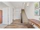 Bright foyer featuring wood floors, staircase, interior door, and decorative artwork at 5173 Vivian St, Wheat Ridge, CO 80033