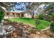 Well-maintained backyard featuring a patio, mature trees, garden and water feature for serene outdoor living at 12662 W Asbury Pl, Lakewood, CO 80228