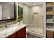 Bathroom with a step-in shower, granite countertop, and a decorative wood-trimmed mirror at 12662 W Asbury Pl, Lakewood, CO 80228