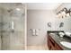 Bathroom featuring a walk-in shower with glass door and double vanity with granite countertops at 12662 W Asbury Pl, Lakewood, CO 80228