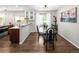Elegant dining room featuring an oval glass top table with modern chairs, stylish lighting, and views to the kitchen at 12662 W Asbury Pl, Lakewood, CO 80228