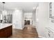 Bright hallway that leads to a kitchen, with hardwood floors and white trim at 12662 W Asbury Pl, Lakewood, CO 80228