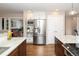 Spacious kitchen showcasing stainless steel refrigerator, island with granite countertop, and modern white and wood cabinets at 12662 W Asbury Pl, Lakewood, CO 80228