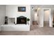 Bright room with a brick fireplace, decorative ironwork, and adjacent hallway at 12662 W Asbury Pl, Lakewood, CO 80228