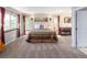 Spacious primary bedroom with carpet flooring, two windows, a piano, and a view of the outdoors at 12662 W Asbury Pl, Lakewood, CO 80228