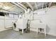 Unfinished basement laundry area includes a washer, dryer, and utility sink at 2945 Grove St, Denver, CO 80211