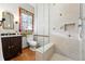 Bathroom featuring glass shower, tiled walls and floors, and decorative window at 2945 Grove St, Denver, CO 80211