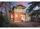 Back exterior elevation featuring a brick facade, balcony, and lush landscaping at 2945 Grove St, Denver, CO 80211