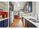 Galley kitchen featuring stainless steel appliances, wood floors and white countertops at 2945 Grove St, Denver, CO 80211