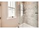 Bright bathroom showcasing a glass enclosed shower with tiled walls, plus a frosted window allowing for natural light and privacy at 7442 Greenwater Cir, Castle Rock, CO 80108