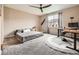 Cozy bedroom with neutral tones, a ceiling fan, modern decor, and a dedicated workspace for comfort and functionality at 7442 Greenwater Cir, Castle Rock, CO 80108