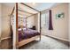 Stylized bedroom featuring a wooden canopy bed, a purple comforter, and a decorative butterfly wallpaper at 7442 Greenwater Cir, Castle Rock, CO 80108