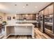 A spacious kitchen featuring stainless steel appliances, an island, granite countertops, and dark wood cabinets at 7442 Greenwater Cir, Castle Rock, CO 80108