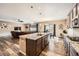 Open-concept kitchen and living area with an island, granite countertops, wood floors, stainless steel appliances, and ample natural light at 7442 Greenwater Cir, Castle Rock, CO 80108