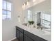 Modern bathroom featuring double sinks, shaker cabinets, decorative accents, and a large mirror at 4096 Estrella St, Brighton, CO 80601