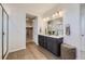 Elegant bathroom with dual sinks, shaker cabinets, a spacious shower, and wood-look flooring at 4096 Estrella St, Brighton, CO 80601