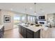 Contemporary kitchen island with pendant lights, open to living area with sliding glass door at 4096 Estrella St, Brighton, CO 80601