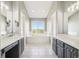 A bright bathroom with double sinks, dark cabinets, a soaking tub, and a large window at 6565 W 99Th Ave, Broomfield, CO 80021