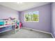 Cozy bedroom with a bunk bed, a desk, a window with a view of the trees, and a purple accent wall at 6565 W 99Th Ave, Broomfield, CO 80021