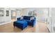Inviting living room with light-colored wood floors, a large window, and a plush blue sofa with ottoman at 6565 W 99Th Ave, Broomfield, CO 80021