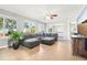 Bright, open living room with a gray sectional sofa, large windows, and access to the dining area at 6565 W 99Th Ave, Broomfield, CO 80021