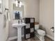 Charming powder room featuring a pedestal sink, modern fixtures, and a decorative storage unit at 2225 S Poppy St, Lakewood, CO 80228