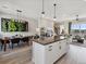 Kitchen with island seating flowing to the dining room with vertical plant art at 2225 S Poppy St, Lakewood, CO 80228