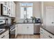 Efficient kitchen with white cabinets, modern appliances, and stylish backsplash at 2225 S Poppy St, Lakewood, CO 80228