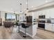 Modern kitchen overlooking the living area featuring an island, stainless steel appliances, and hardwood floors at 2225 S Poppy St, Lakewood, CO 80228