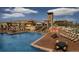 Community pool surrounded by lounge chairs, tables, and landscaping with views of the mountains at 2225 S Poppy St, Lakewood, CO 80228