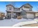 Two-story house with gray exterior, stone accents, and three-car garage, snow on ground at 16382 Spanish Peak Way, Broomfield, CO 80023