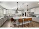 Modern kitchen with white cabinets, large island, and stainless steel appliances at 16382 Spanish Peak Way, Broomfield, CO 80023