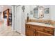 Half bathroom features an oak vanity cabinet, decorative mirror, and neutral tile flooring at 4900 Beverly Dr, Berthoud, CO 80513