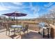 A deck features a gas grill, table, chairs, and a purple patio umbrella overlooking a grassy field at 4900 Beverly Dr, Berthoud, CO 80513