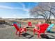 Outdoor fire pit area with colorful Adirondack chairs surrounded by beautiful landscape views at 4900 Beverly Dr, Berthoud, CO 80513