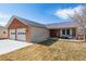 Charming brick and siding home with a well-manicured front lawn and attached garage at 4900 Beverly Dr, Berthoud, CO 80513