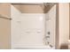 A well-lit bathtub-shower combo featuring a white tiled surround and chrome fixtures at 17224 Lark Water Ln # D, Parker, CO 80134