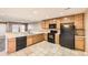 Bright kitchen with tile floors, wood cabinets, and black appliances at 17224 Lark Water Ln # D, Parker, CO 80134
