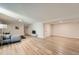 Open basement living room with seating, television, light wood flooring, and neutral walls at 6923 S Albion St, Centennial, CO 80122