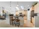 Kitchen features a breakfast bar, skylights, and light wood cabinets at 1950 Five Iron Dr, Castle Rock, CO 80104