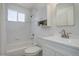 Bathroom featuring a shower-tub, white tiled walls, and vanity storage at 525 W Midway Blvd, Broomfield, CO 80020