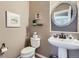 Stylish powder room with pedestal sink, decorative mirror, and neutral palette at 4993 Sedona Cir, Parker, CO 80134