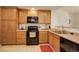 View of kitchen with wood cabinets and black appliances at 8865 Federal Blvd # 201, Westminster, CO 80260