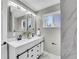 Bathroom with a dual sink vanity featuring black hardware and white marble counters at 3272 W Stanford W Ave, Englewood, CO 80110