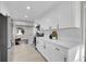 Bright kitchen featuring white cabinets, stainless steel appliances, quartz countertops, and light wood floors at 3272 W Stanford W Ave, Englewood, CO 80110