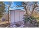 White shed with a gray roof situated in a landscaped area of the backyard at 3272 W Stanford W Ave, Englewood, CO 80110