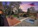 Spacious backyard with a brick patio, gazebo and fire pit illuminated by string lights at dusk at 7071 Beach St, Westminster, CO 80030