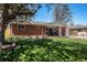 Charming red brick single-story home with a well-manicured lawn and mature shade trees at 7071 Beach St, Westminster, CO 80030